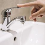 crop-hand-touching-tap-with-streaming-water_23-2147765053