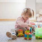 Kako odabrati poklon za dete prema uzrastu cute-girl-sitting-carpet-playing_23-2147663655