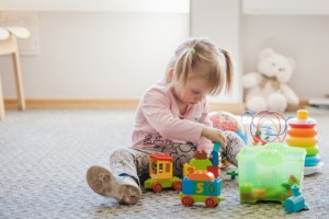 cute-girl-sitting-carpet-playing_23-2147663655