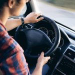 Young driver in his shirt in a nice modern car in motion