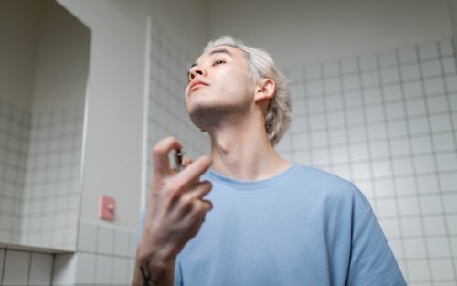 muskarac stavlja parfem na sebe