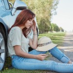 devojka sedi pored automobila