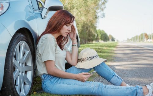 devojka sedi pored automobila