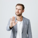 muskarac sa podignutom sakom kao znak stani , sacekaj, razmisli