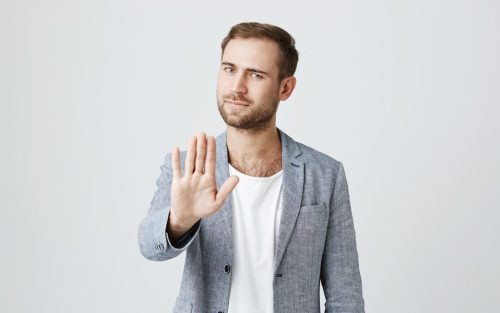 muskarac sa podignutom sakom kao znak stani , sacekaj, razmisli