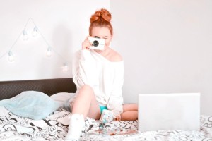 Devojka na krevetu sa fotoaparatom