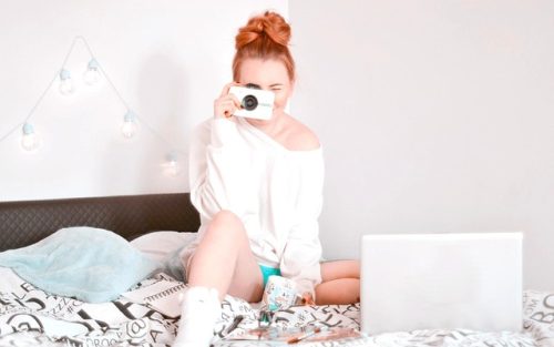 Devojka na krevetu sa fotoaparatom